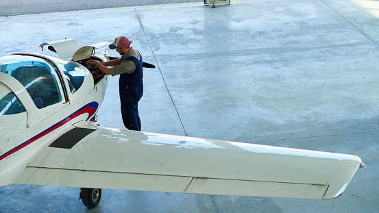 Aircraft mechanic working on propeller airplane in hangar