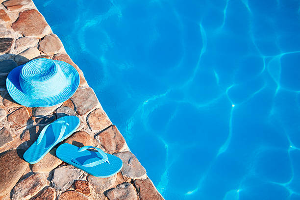 istock Blue  hat  and flip flop by a swimming pool 481437076