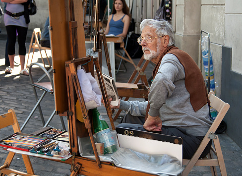 Paris, France - June 07, 2010: Painter and his easel in Place du Tertre of Montmartre, which is a cobbled square and a hangout for buskers and artists painting landscapes and tourist portraits.