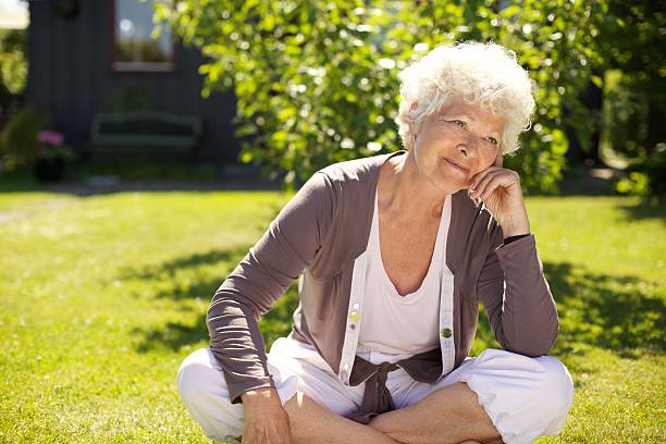 istock Senior woman sitting outdoors lost in thoughts 481438637