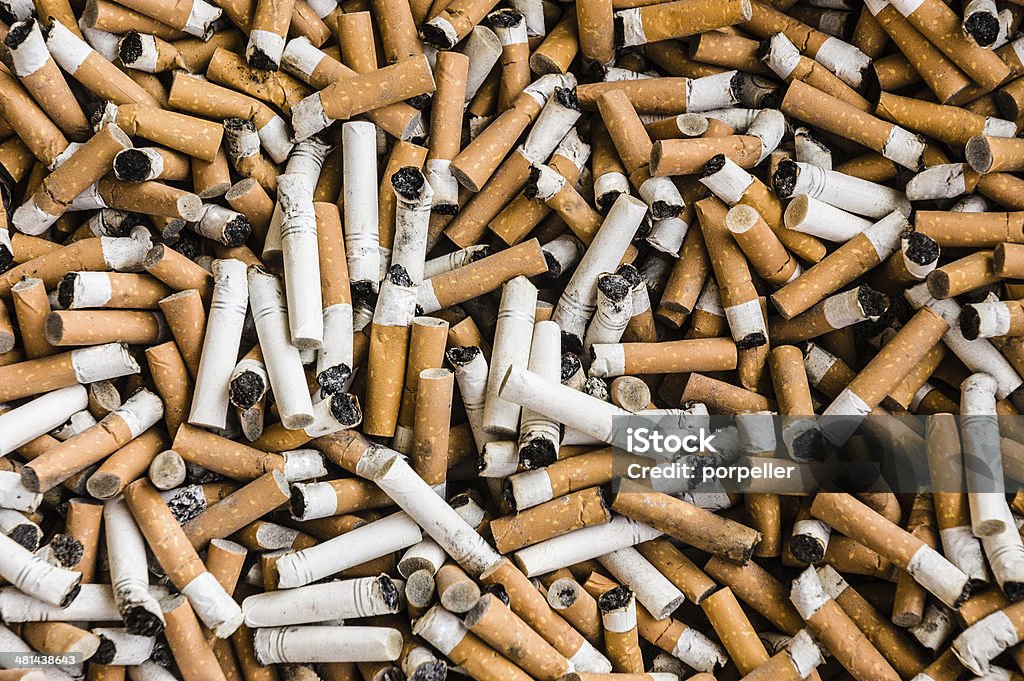 Cigarettes a lot of burnt cigarette butts with some ash Cigarette Butt Stock Photo