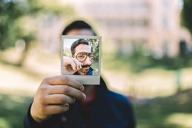 istock Man holding instant photo 481440106