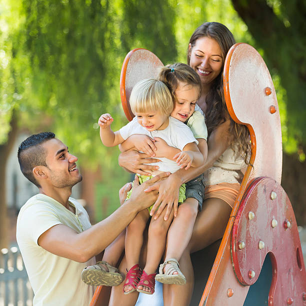 istock Family playing at children's slide 481444508