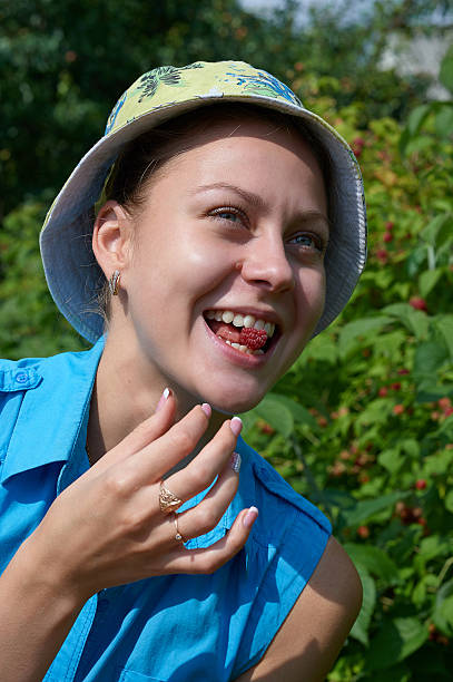 istock the girl smiles in a garden with raspberry 481446878