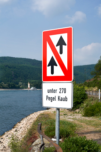 No overtaking/no passing area for ships - german navigation sign at River Rhine. In the background the famous Maueseturm at Binger Loch