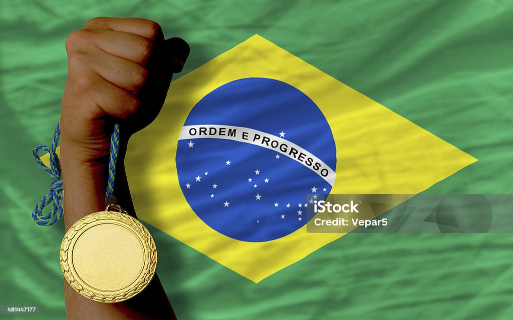 Gold medal for sport and  national flag of brazil Winner holding gold medal for sport and national flag of brazil Achievement Stock Photo