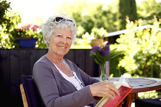 istock Senior woman in garden with a book 481447379