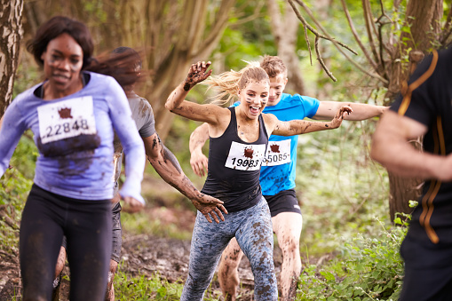 Competidores corriendo en el bosque en un evento de resistencia photo