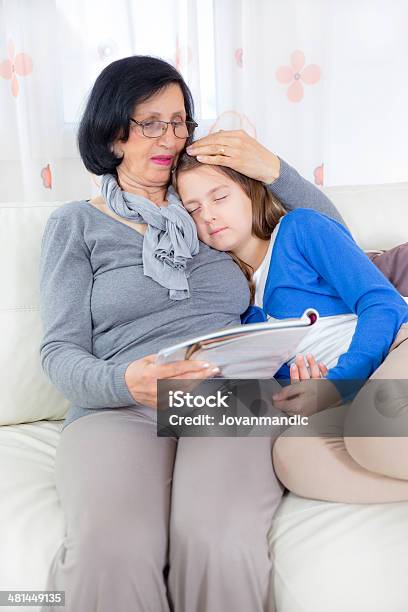 Grandmother And Granddaughter With Magazine Stock Photo - Download Image Now - 60-69 Years, 8-9 Years, Active Seniors