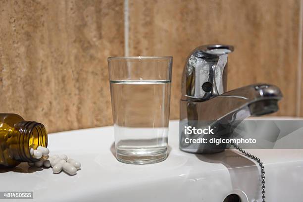 Glass Of Water And Pile Of Blister Packs In Bathroom Stock Photo - Download Image Now