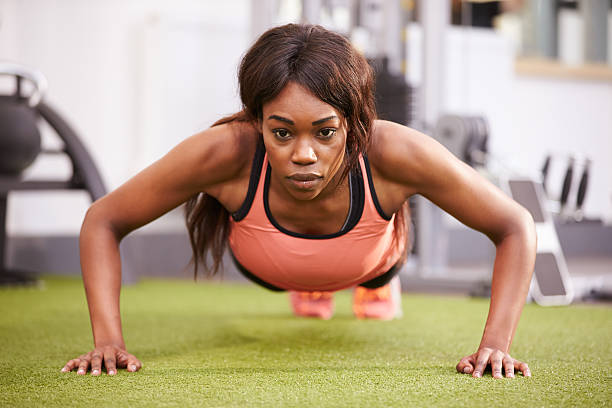 istock Young woman doing push ups at a gym 481450810