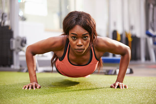 istock Young woman doing push ups at a gym 481450828