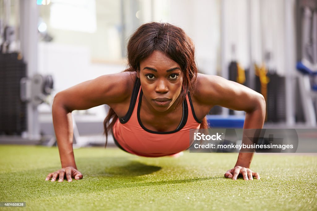 Young woman doing push ups at a gym 20-29 Years Stock Photo