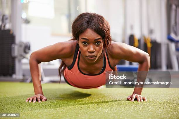 Young Woman Doing Push Ups At A Gym Stock Photo - Download Image Now - 20-29 Years, 2015, Achievement