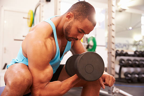 Man exercising with dumbbells at a gym, horizontal shot Man exercising with dumbbells at a gym ripl fitness