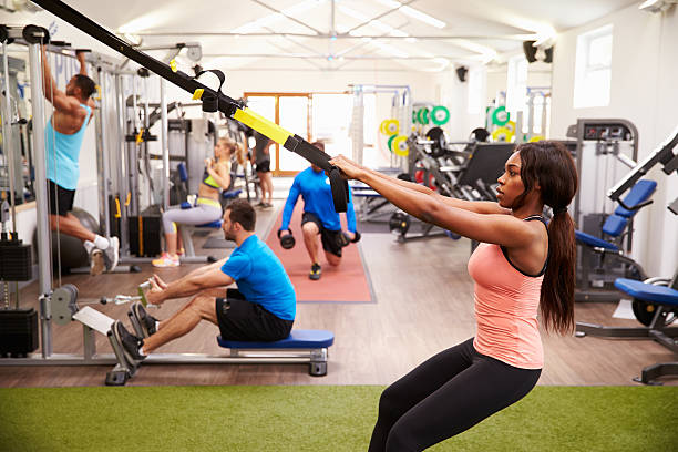 gente trabajando en equipos de ejercicios en el gimnasio de trabajo - body building gym human muscle effort fotografías e imágenes de stock