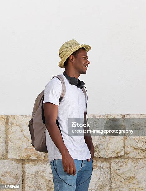 Happy Young Guy Outdoors With Hat And Bag Stock Photo - Download Image Now - 20-29 Years, 2015, Adult