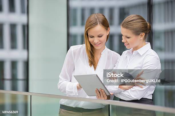 Businesswomen Using Digital Tablet In Office Stock Photo - Download Image Now - 18-19 Years, 30-34 Years, 30-39 Years