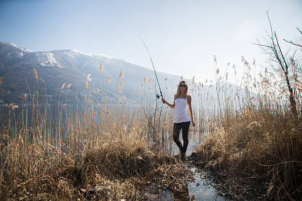 istock Young woman fishing 481460373