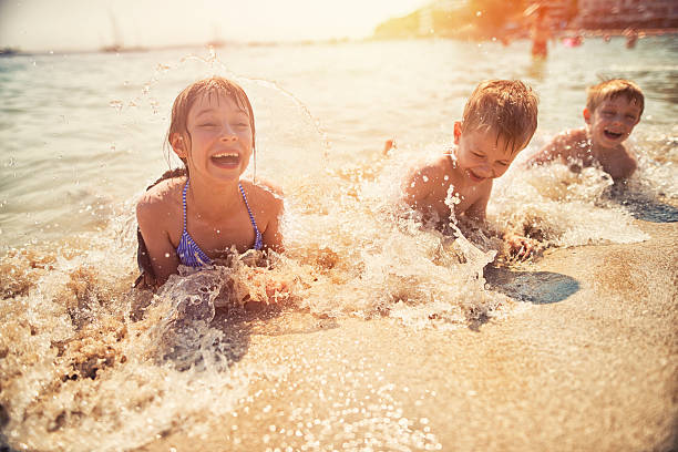 Kids having fun in sea lying on beach