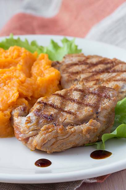 istock Pork steak fried on grill with mashed sweet potatoes, tasty 481463963