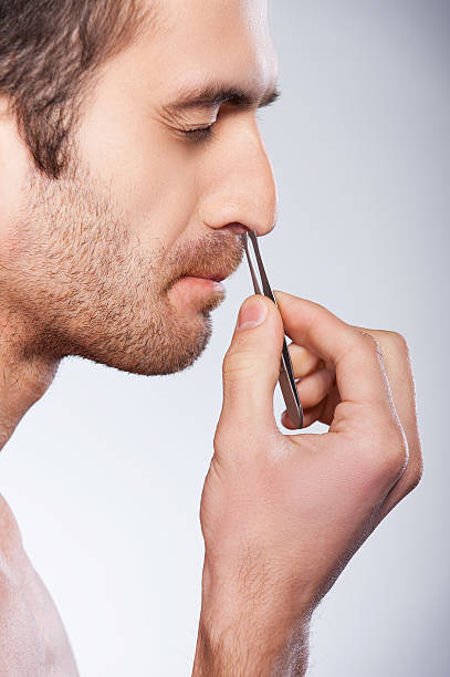 istock Man tweezing hair from nose. 481464477