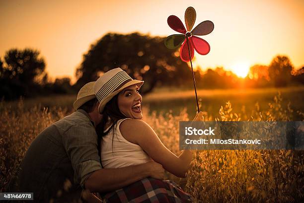 Loving Couple In Field At Sunset Stock Photo - Download Image Now - 2015, Adult, Adults Only