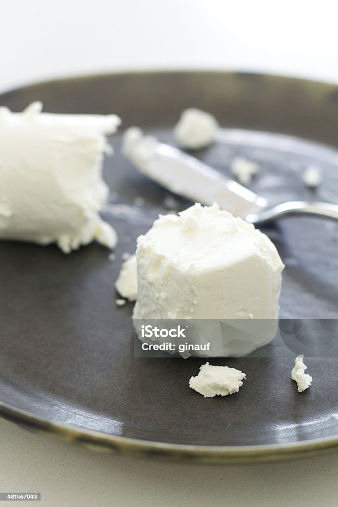 Goat Cheese a photograph of goat cheese resting on a handmade ceramic grey plate Ceramics Stock Photo