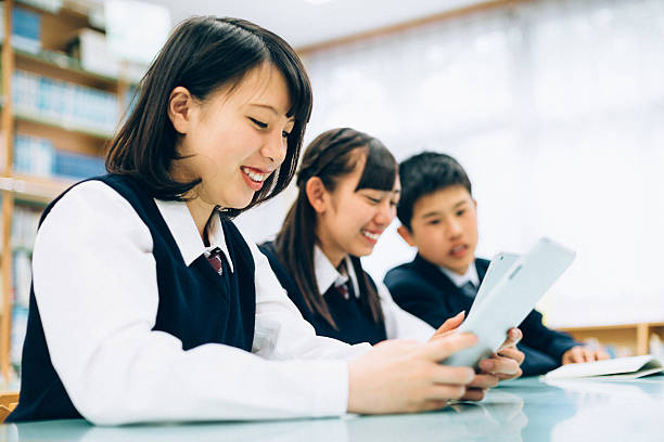 istock Japanese female students reading on digital tablet in library 481470956