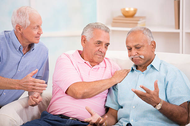 istock Diverse group of senior men console a friend. Home setting. 481471102