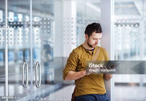 Giovane Uomo Utilizzando Un Tablet Allaeroporto - Fotografie stock e altre immagini di Abbigliamento formale - Abbigliamento formale, Adulto, Aeroporto