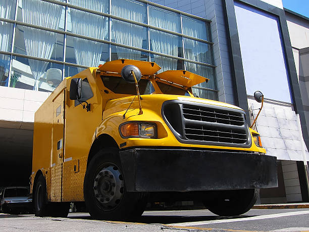Yellow armored truck Yellow armored truck in front of a bank armored vehicle photos stock pictures, royalty-free photos & images
