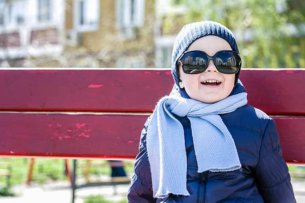 istock boy with glasses and scarf looks at the sun 481475978