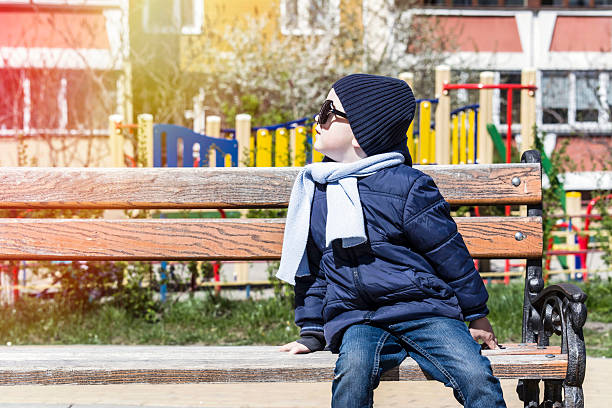 istock boy with glasses and scarf looks at the sun 481475998