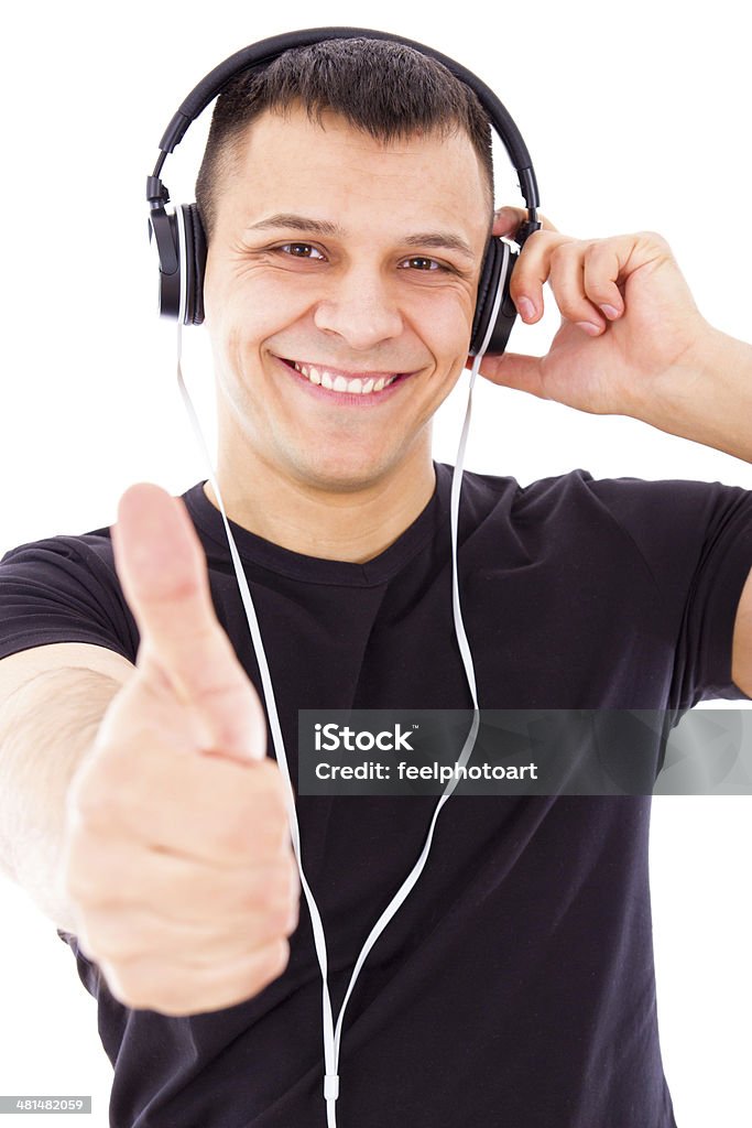 Sonriente hombre atractivo escuchar música mostrando pulgar hacia arriba - Foto de stock de Adulto libre de derechos