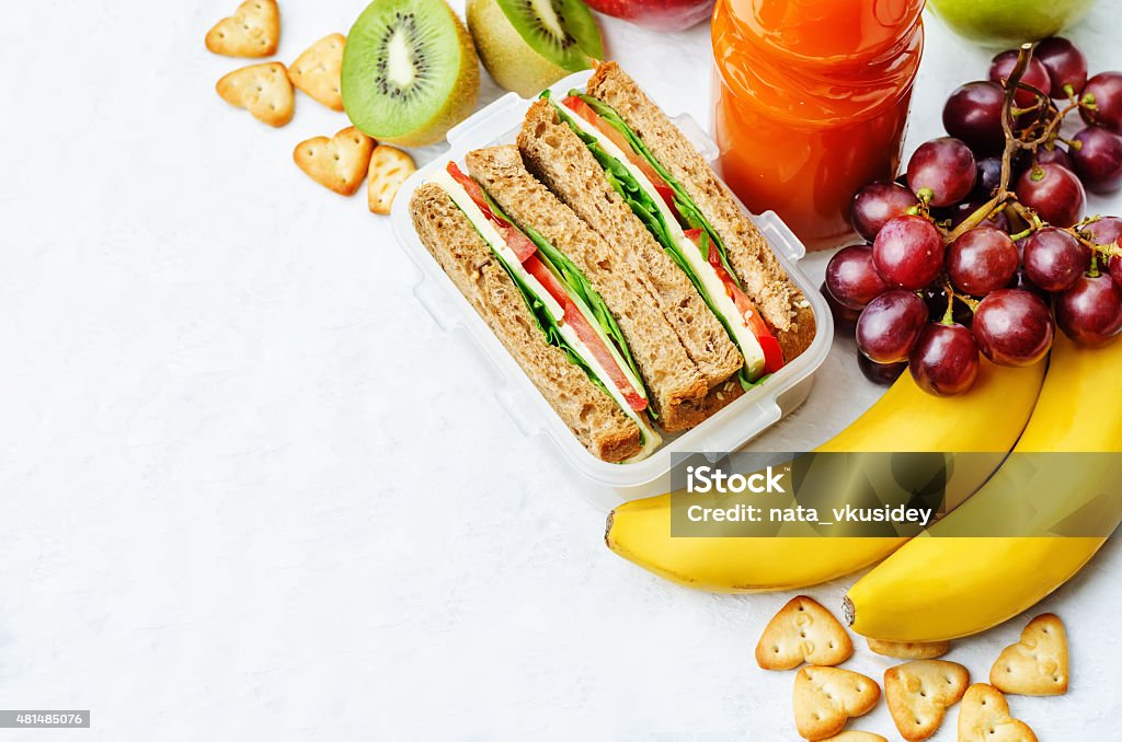 school lunch with a sandwich, fresh fruits, crackers and juice school lunch with a sandwich, fresh fruits, crackers and juice. the toning. selective focus Bento Box Stock Photo