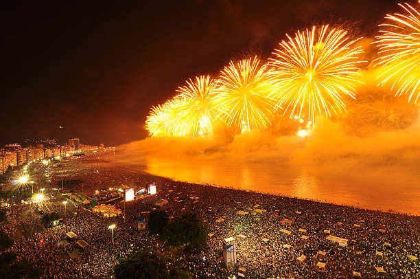 New Year´s Eve Party on Copacabana Beach More than 2 million people attended 2013-2014 New Year´s Eve celebration on Copacabana beach in Rio de Janeiro, Brazil. The celebration included amazing firework show that lasted 16 minutes and 3 stages with live music concert. The fireworks were set off from 11 barges positioned 300 m from the beach.  copacabana rio de janeiro stock pictures, royalty-free photos & images