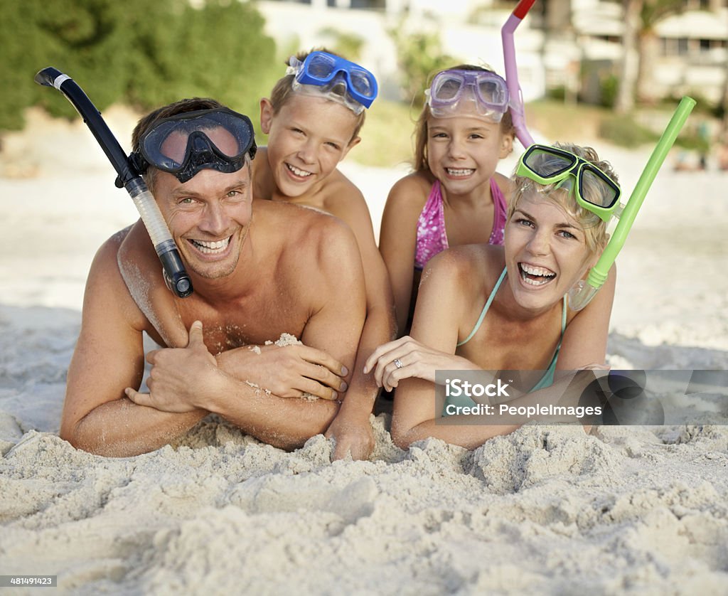 Exploring the wonders of snorkeling together A family in snorkeling gear lying on the sand at the beach Snorkeling Stock Photo