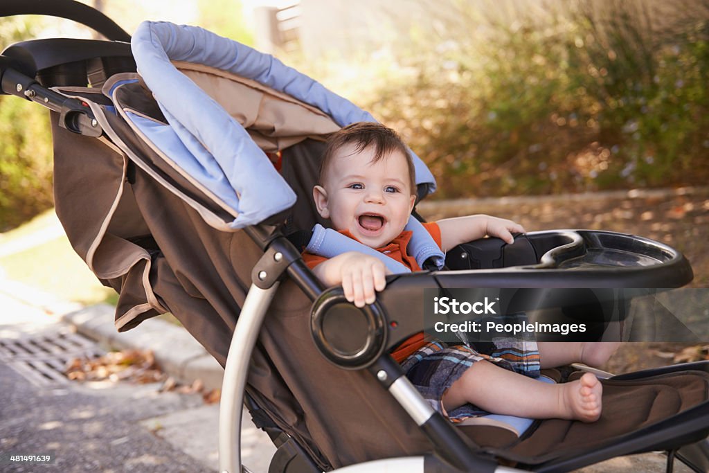 Baby's transport Portrait of a baby boy sitting in a stroller outside Baby Stroller Stock Photo