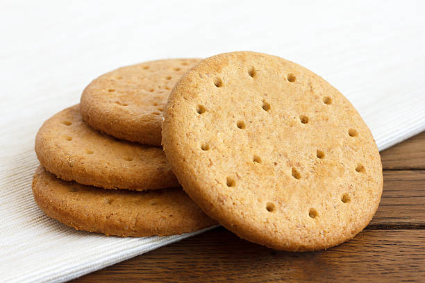 istock Stack of sweetmeal digestive biscuits on dark wood and napkin. 481495136
