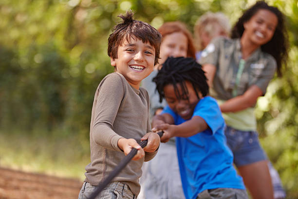 Pull! A group of kids in a tug-of-war game playful stock pictures, royalty-free photos & images