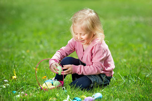 istock Little girl picking up easter eggs outdoors 481496013