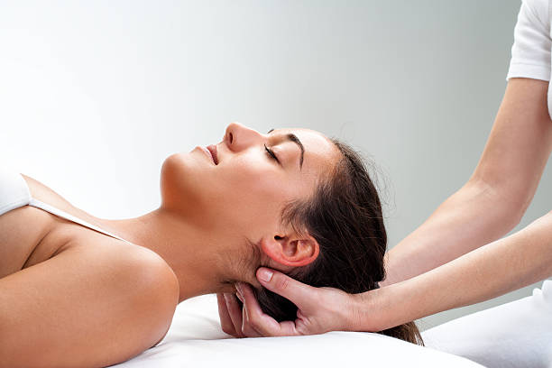 womans physiotherapist premindo parte de trás da cabeça. - reiki alternative therapy massaging women imagens e fotografias de stock