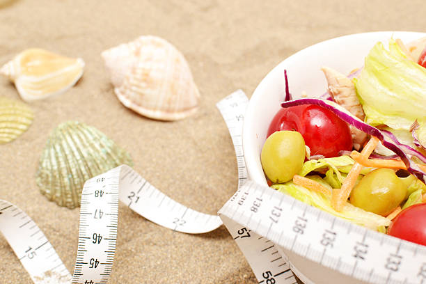 istock Salad, tape measure and shells on sand 481501400