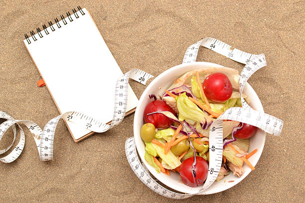 istock Salad, tape measure and shells on sand 481507878