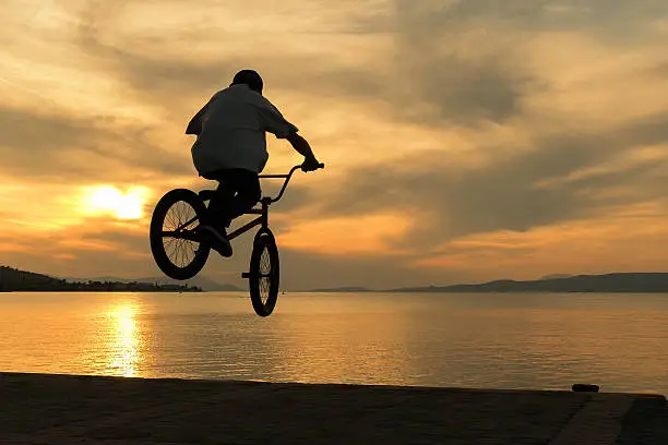 Beautiful sunset and biker's tricks.