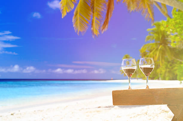 istock two wine glasses on sand beach 481516380