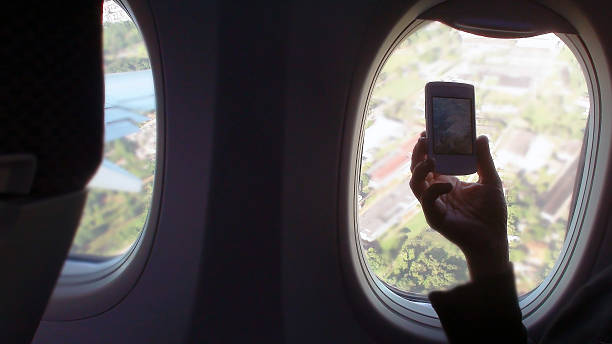 istock Hand Recording Landscape With Smartphone Through Airplane Window 481516942
