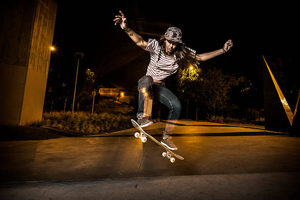 Female skateboarder jumping in the city at night