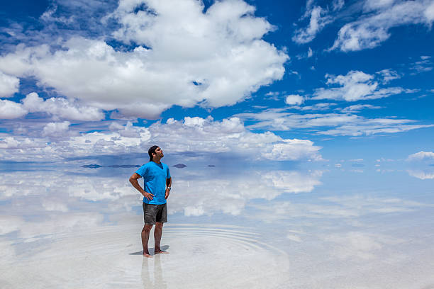 男性に立つウユニ塩湖、ボリビア、2 月 - ウユニ塩湖 ストックフォトと画像